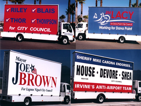 An Image of Multiple Mobile Billboards Of Political Campaigns.