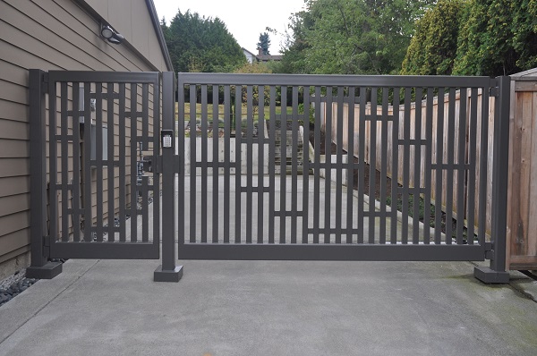 Grey coloured swing gate at the side of the countryside house.