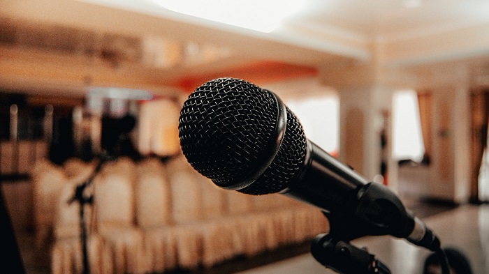 Close up shot of a mic that is kept ready on the stage for receiving speech from a popular orator or speaker.