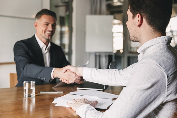 A canditate shaking hands with his interviewer after a successful interview