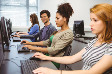 Image of four trainees learning on desktop computers in a software training institute.