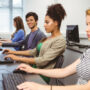 Image of four trainees learning on desktop computers in a software training institute.