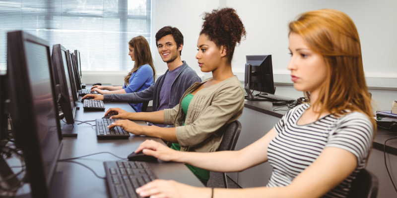 Image of four trainees learning on desktop computers in a software training institute.